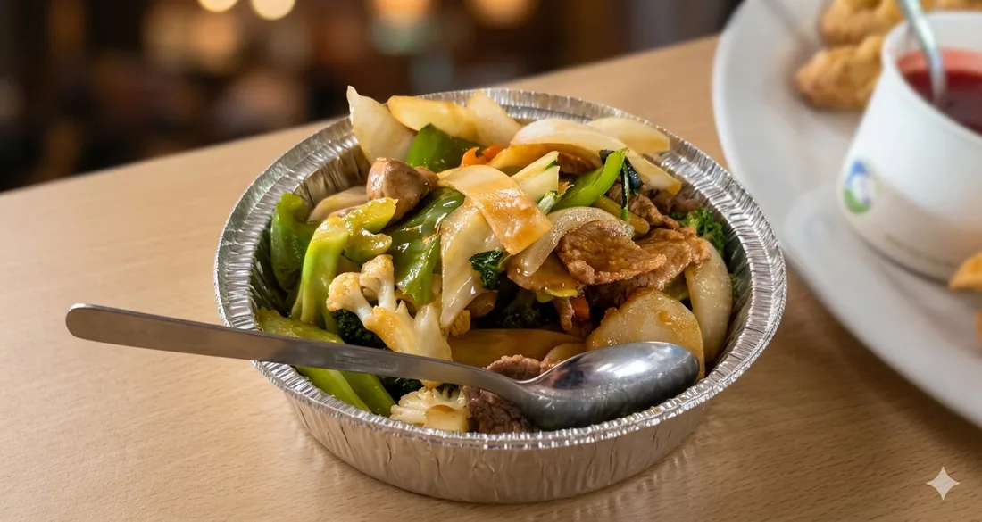 Wok-fired sliced beef with crisp green vegetables in a bowl, with tea